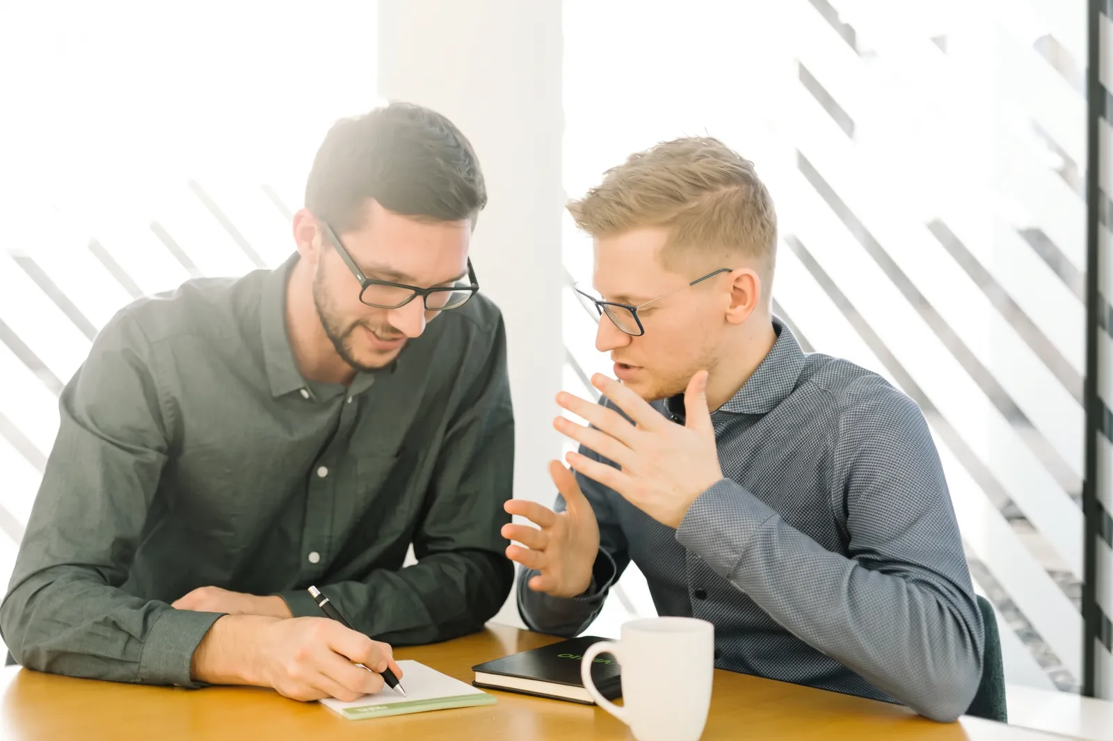 Zwei Berater von QMedia IT arbeiten gemeinsam an einer Einführung
